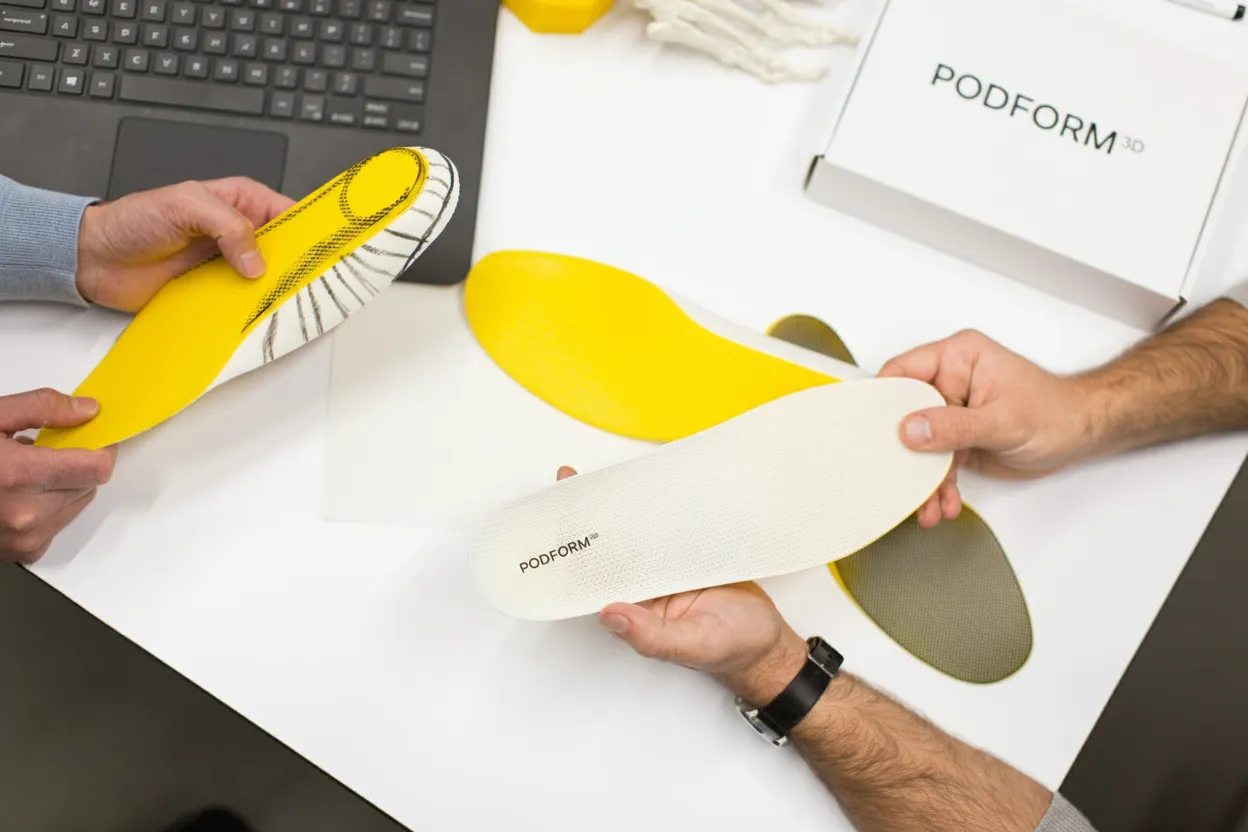 Multiple Podform3D orthotic iterations being compared side by side on a desk