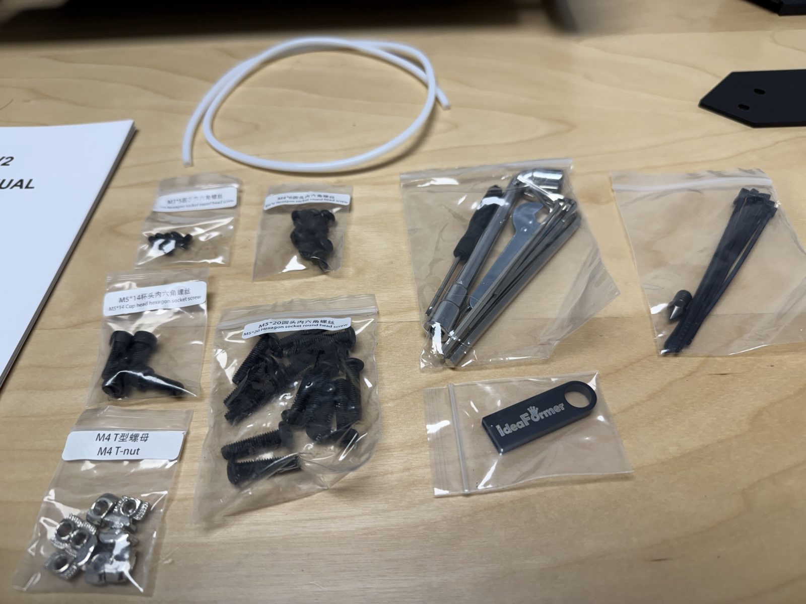 Close-up photo of small hardware, hex keys, and PTFE tube